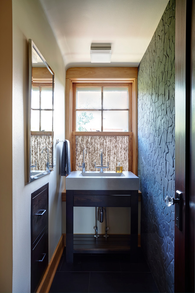 Cette photo montre une petite salle d'eau asiatique en bois foncé avec un placard sans porte, WC à poser, un carrelage gris, un carrelage de pierre, un mur jaune, un sol en carrelage de céramique et un plan de toilette en béton.
