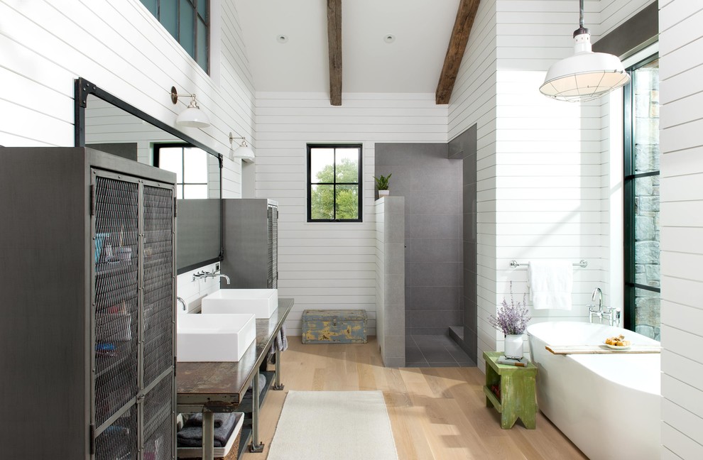 На фото: главная ванная комната в стиле кантри с открытыми фасадами, отдельно стоящей ванной, открытым душем, белыми стенами, светлым паркетным полом, настольной раковиной, бежевым полом, открытым душем и зеркалом с подсветкой