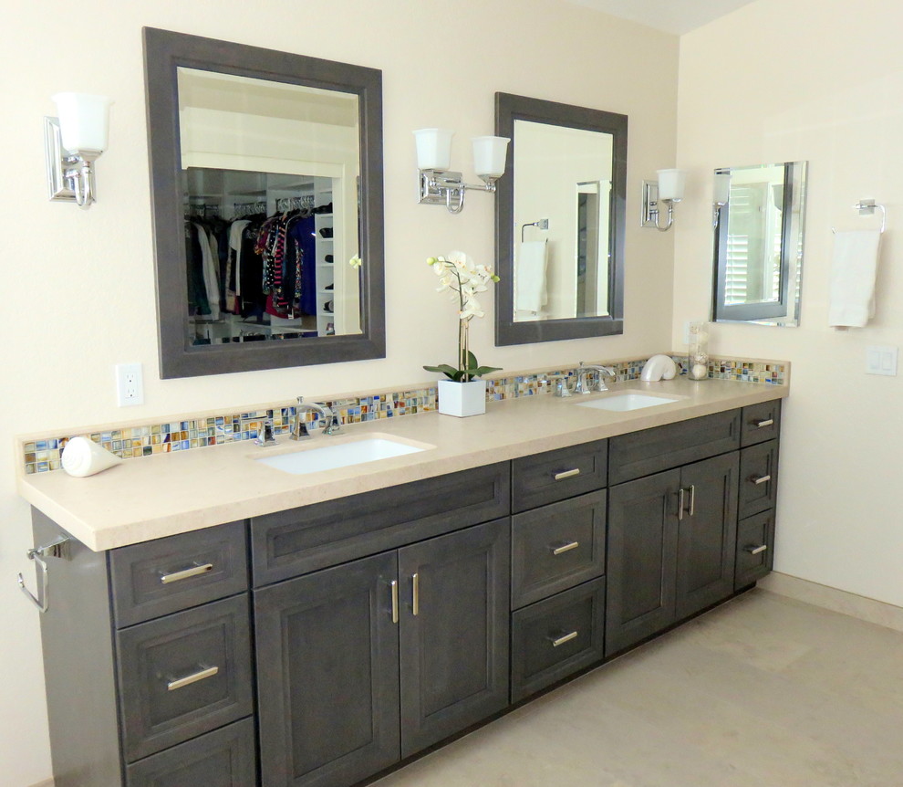 Large classic ensuite bathroom in Orange County with shaker cabinets, medium wood cabinets, a built-in bath, a one-piece toilet, beige tiles, porcelain tiles, white walls, porcelain flooring, a submerged sink and limestone worktops.