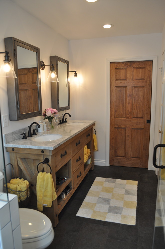 Esempio di una stanza da bagno stile marino di medie dimensioni con ante lisce, ante in legno chiaro, pavimento con piastrelle in ceramica e pavimento nero