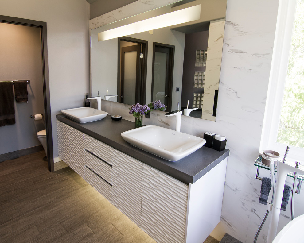 Пример оригинального дизайна: ванная комната в современном стиле с настольной раковиной, белыми фасадами, столешницей из искусственного кварца, белой плиткой, керамогранитной плиткой и плоскими фасадами