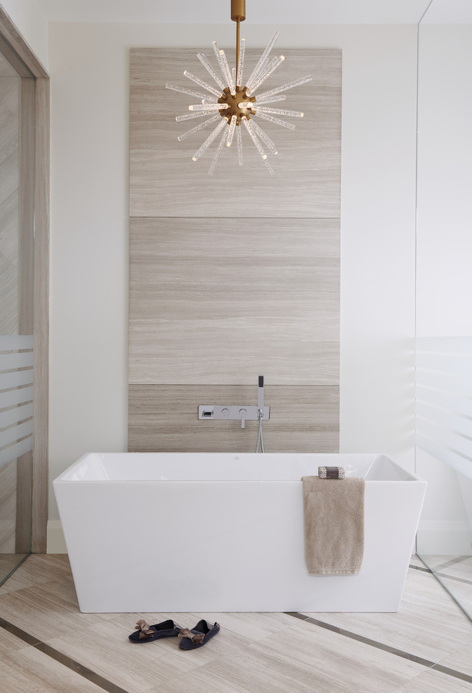Cette photo montre une salle de bain moderne en bois brun avec un placard à porte plane, une baignoire indépendante, un mur blanc, un lavabo posé, un sol beige et un plan de toilette beige.