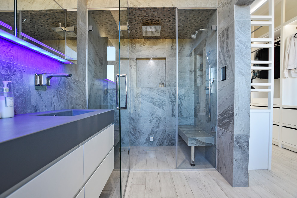 Aménagement d'une grande salle de bain moderne avec une douche double, un sol en carrelage imitation parquet, une cabine de douche à porte battante, mosaïque et un plan de toilette en béton.