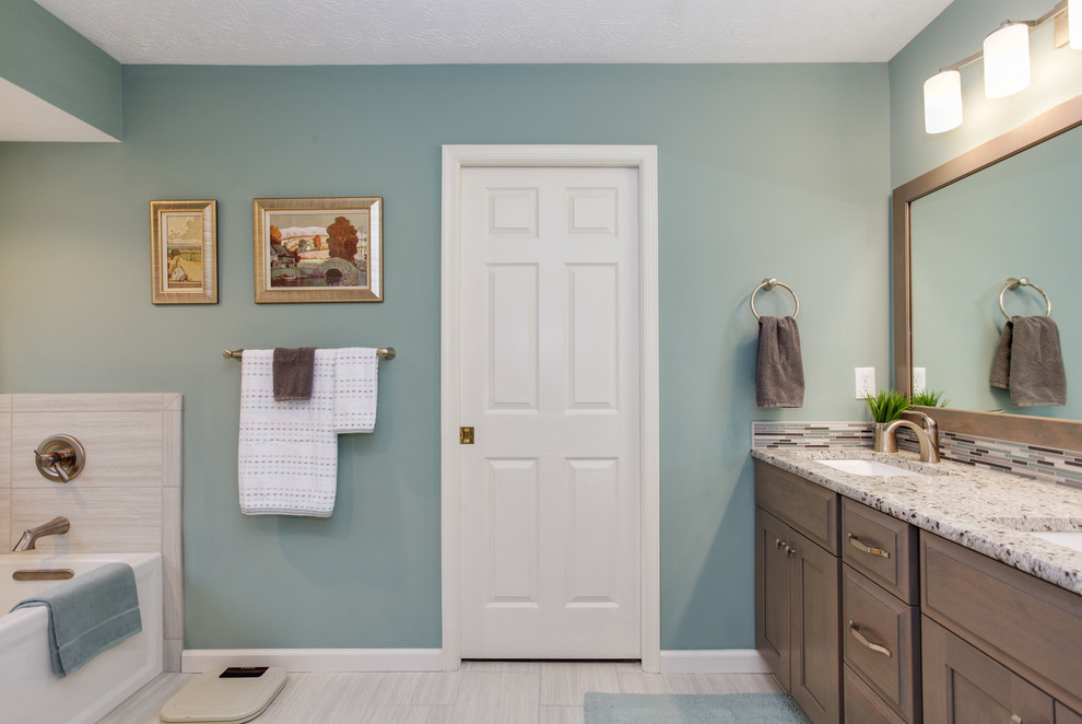 Пример оригинального дизайна: главная ванная комната среднего размера в стиле неоклассика (современная классика) с фасадами в стиле шейкер, фасадами цвета дерева среднего тона, ванной в нише, душем в нише, раздельным унитазом, серой плиткой, керамогранитной плиткой, зелеными стенами, полом из керамогранита, врезной раковиной, столешницей из гранита, серым полом, душем с распашными дверями и серой столешницей