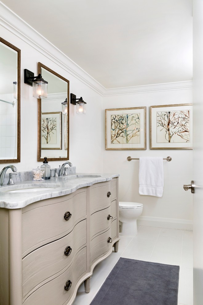 Imagen de cuarto de baño clásico con lavabo bajoencimera, puertas de armario grises, paredes blancas y armarios con paneles lisos