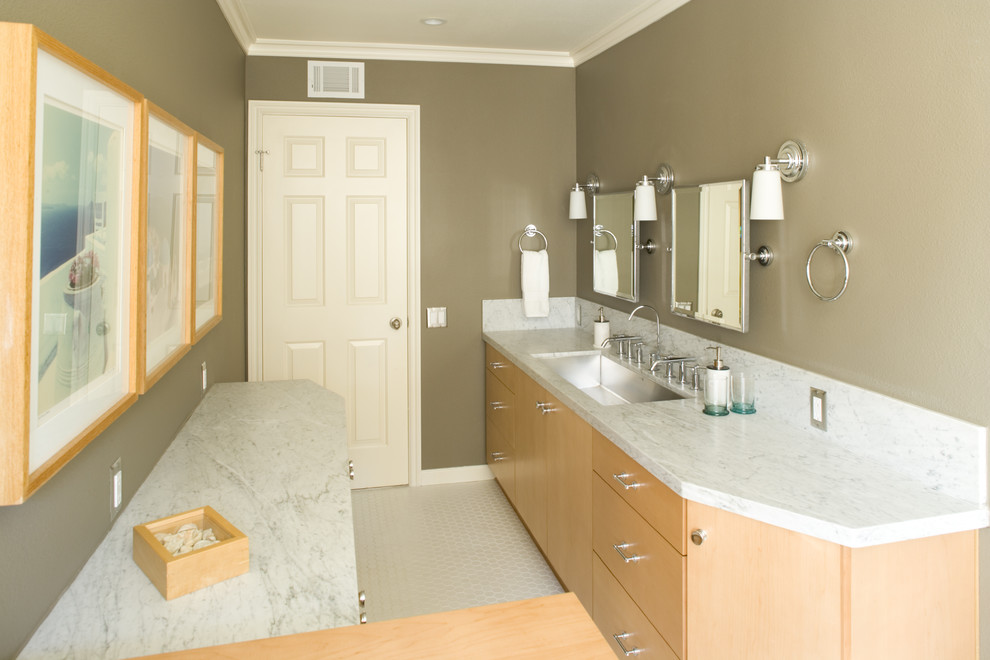 Example of a mid-sized trendy ceramic tile and white floor bathroom design in Los Angeles with flat-panel cabinets, light wood cabinets, beige walls, a trough sink and marble countertops