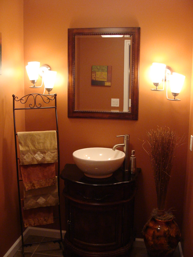 Immagine di una piccola stanza da bagno con doccia etnica con ante con bugna sagomata, ante in legno bruno, pareti arancioni, pavimento con piastrelle in ceramica, lavabo a bacinella e top in superficie solida