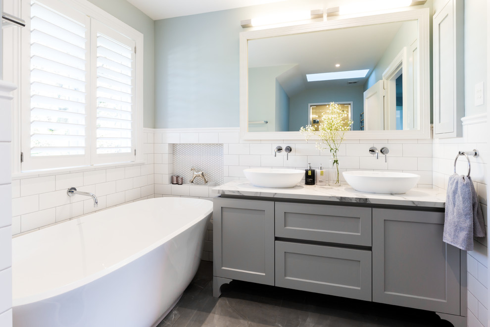 Свежая идея для дизайна: детская ванная комната в стиле неоклассика (современная классика) с фасадами в стиле шейкер, серыми фасадами, отдельно стоящей ванной, душем в нише, синими стенами, настольной раковиной, серым полом, душем с распашными дверями, белой столешницей, белой плиткой, керамогранитной плиткой и полом из керамогранита - отличное фото интерьера