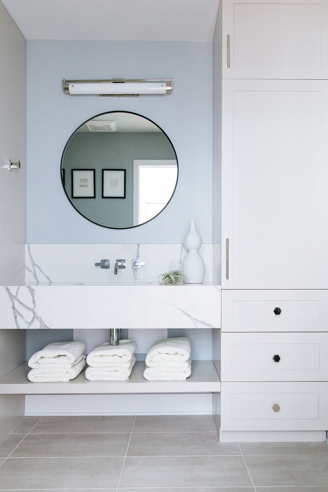 Aménagement d'une salle d'eau contemporaine de taille moyenne avec un placard sans porte, une baignoire en alcôve, un combiné douche/baignoire, un carrelage noir, des carreaux de béton, un mur bleu, un sol en travertin, un lavabo encastré, un plan de toilette en marbre, un sol beige, une cabine de douche à porte battante et un plan de toilette blanc.