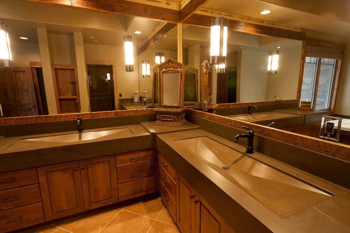 他の地域にあるラグジュアリーな広いラスティックスタイルのおしゃれなマスターバスルーム (一体型シンク、コンクリートの洗面台、ドロップイン型浴槽、ベージュのタイル、石タイル) の写真