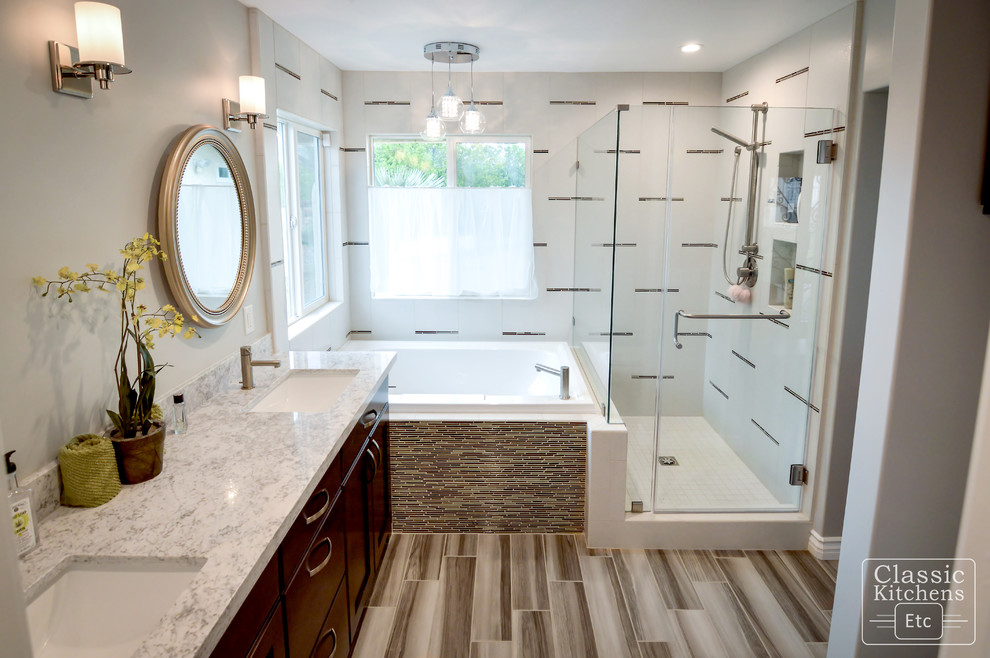 Photo of a medium sized contemporary ensuite bathroom with recessed-panel cabinets, dark wood cabinets, a built-in bath, a corner shower, a two-piece toilet, beige tiles, porcelain tiles, grey walls, porcelain flooring, a submerged sink and marble worktops.