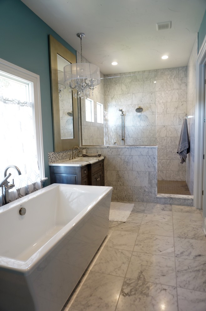 Foto på ett stort amerikanskt flerfärgad en-suite badrum, med ett konsol handfat, möbel-liknande, grå skåp, marmorbänkskiva, ett fristående badkar, en öppen dusch, vit kakel, blå väggar, klinkergolv i keramik och med dusch som är öppen