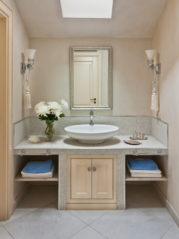 Diseño de cuarto de baño tradicional con lavabo sobreencimera, armarios con rebordes decorativos, puertas de armario beige, baldosas y/o azulejos blancos, baldosas y/o azulejos en mosaico y paredes beige