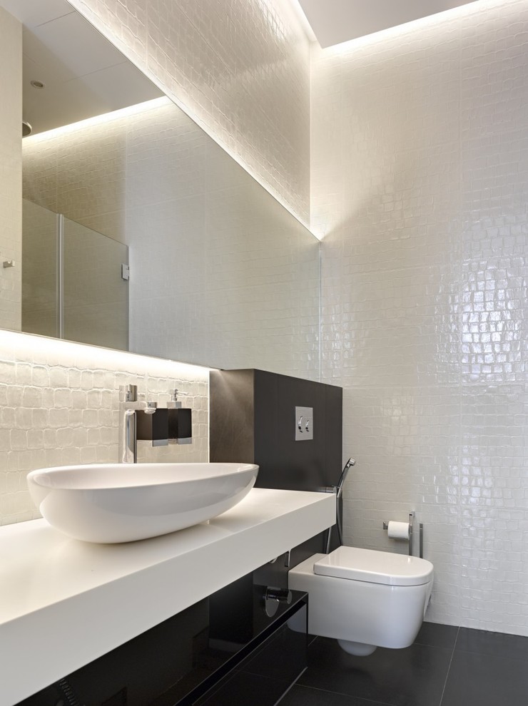 Réalisation d'une salle de bain design avec WC suspendus, un mur blanc et une vasque.