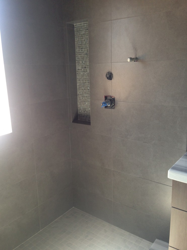 Aménagement d'une grande salle de bain contemporaine avec un lavabo encastré, un plan de toilette en marbre, une baignoire indépendante, WC à poser, un carrelage gris, des carreaux de porcelaine, un mur bleu et un sol en carrelage de porcelaine.