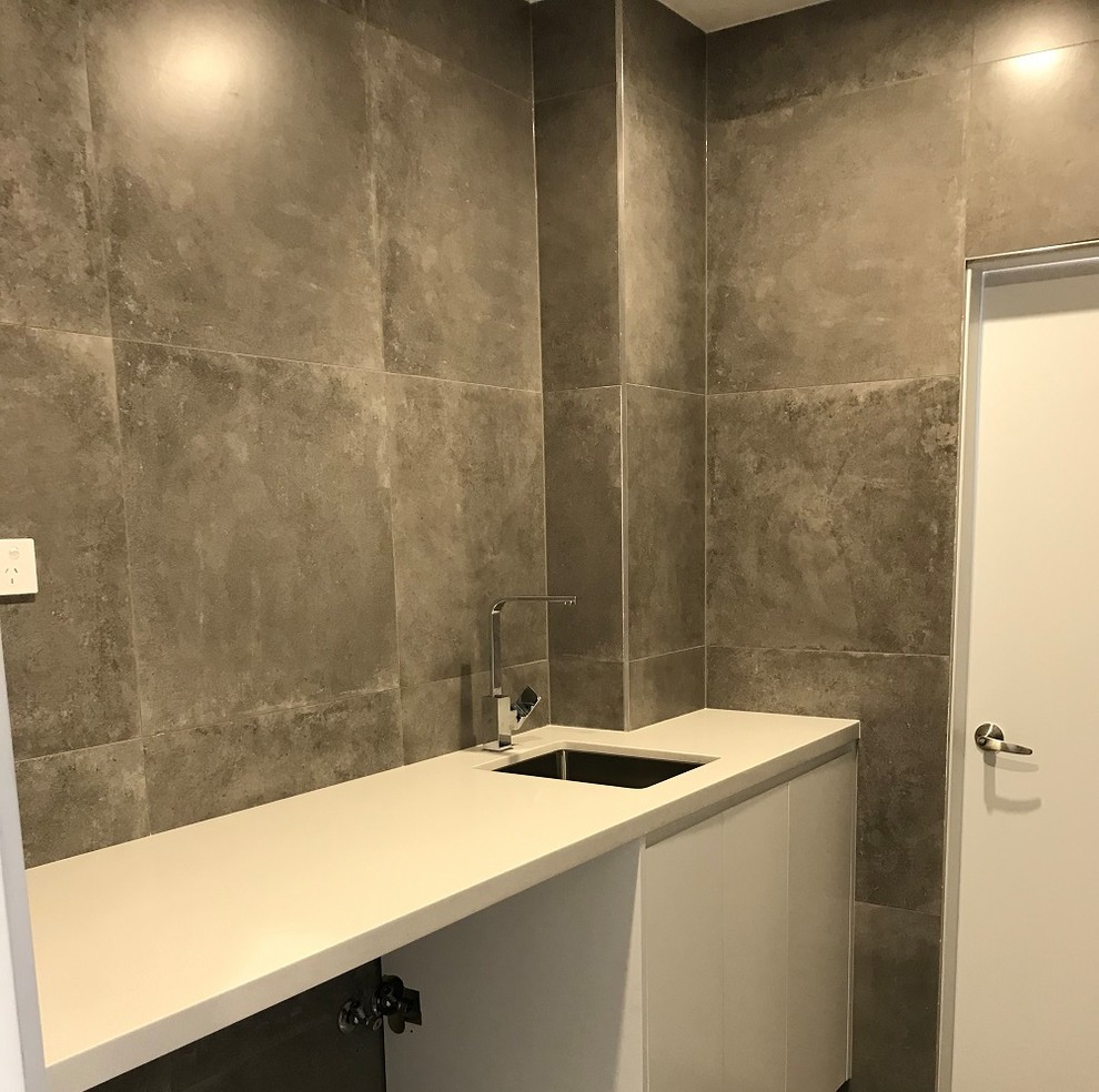 Mittelgroßes Industrial Badezimmer mit Toilette mit Aufsatzspülkasten, grauen Fliesen, Porzellanfliesen, grauer Wandfarbe, Porzellan-Bodenfliesen, Wandwaschbecken und grauem Boden in Sydney