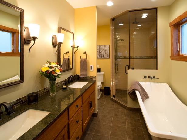 Ejemplo de cuarto de baño clásico renovado con lavabo bajoencimera, puertas de armario de madera oscura, encimera de granito, bañera exenta, ducha esquinera, baldosas y/o azulejos beige, baldosas y/o azulejos de piedra y paredes amarillas