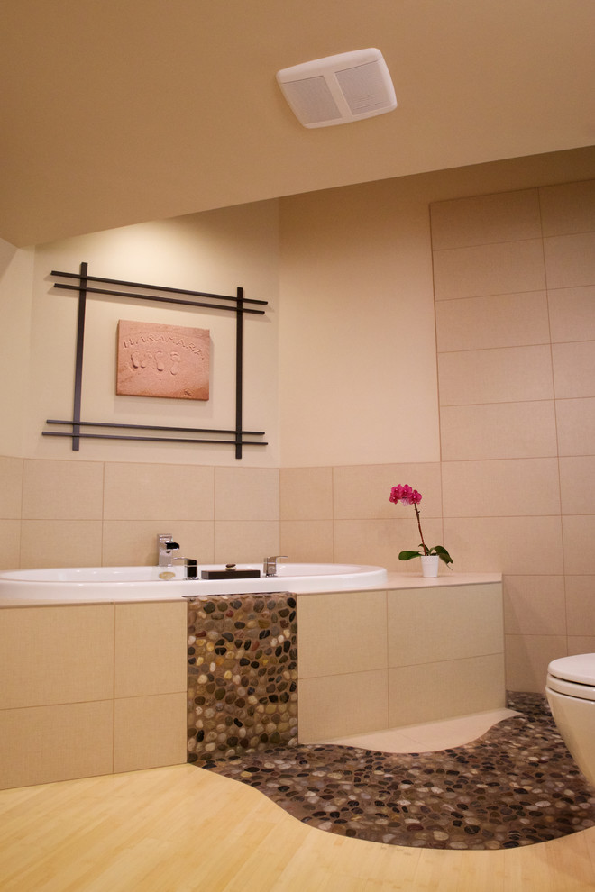 На фото: ванная комната в восточном стиле с накладной ванной и бежевой плиткой