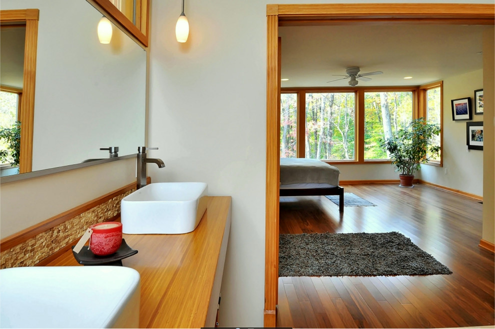 Foto di una grande stanza da bagno padronale minimalista con lavabo a bacinella, ante in legno chiaro, top in legno, WC monopezzo, piastrelle beige, piastrelle in pietra, pareti beige e pavimento in travertino