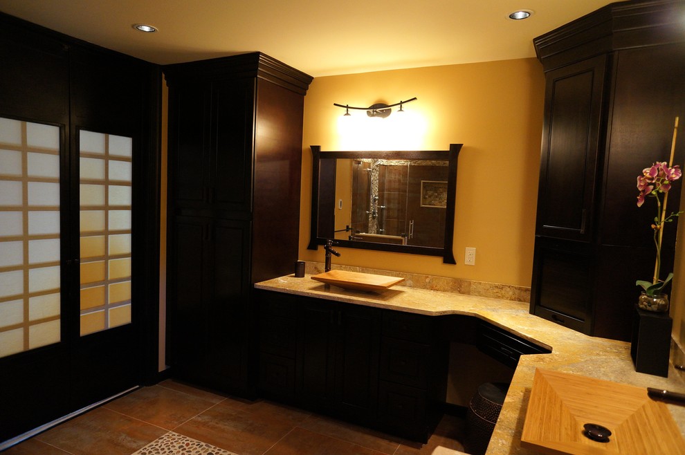 Inspiration for a mid-sized zen master slate floor alcove shower remodel in Philadelphia with raised-panel cabinets, black cabinets, a wall-mount toilet, brown walls, a vessel sink and limestone countertops