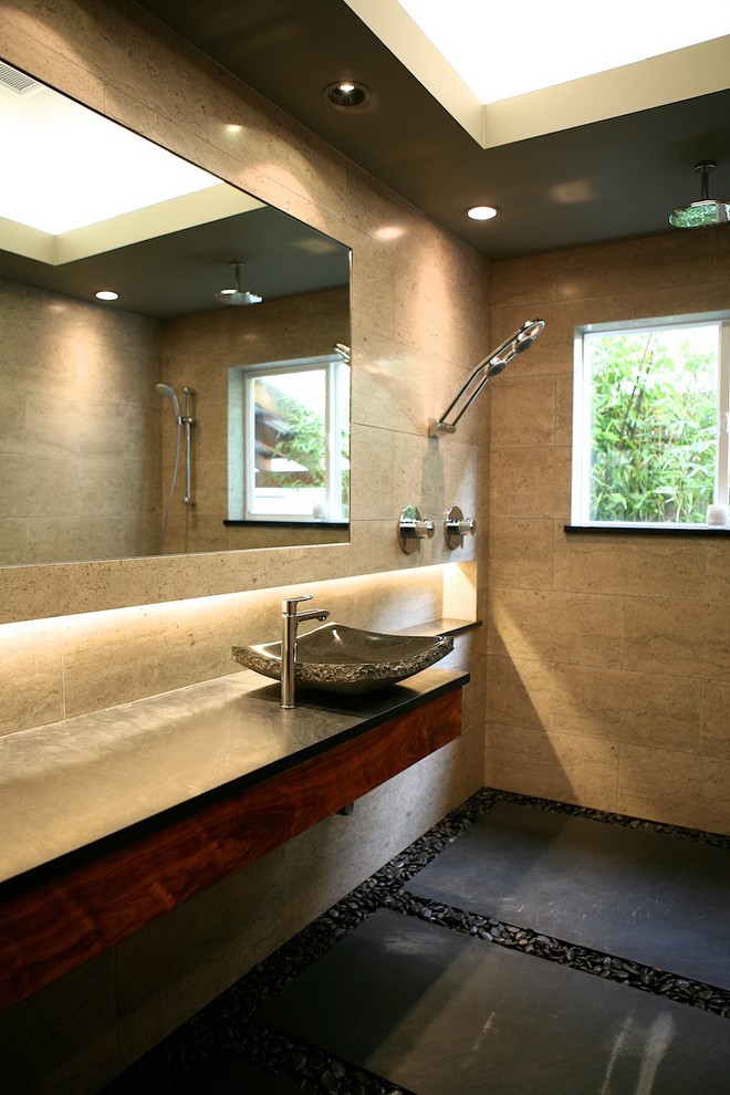 Idéer för mellanstora orientaliska en-suite badrum, med ett fristående handfat, släta luckor, skåp i mörkt trä, bänkskiva i täljsten, en kantlös dusch, grå kakel, stenkakel och grå väggar