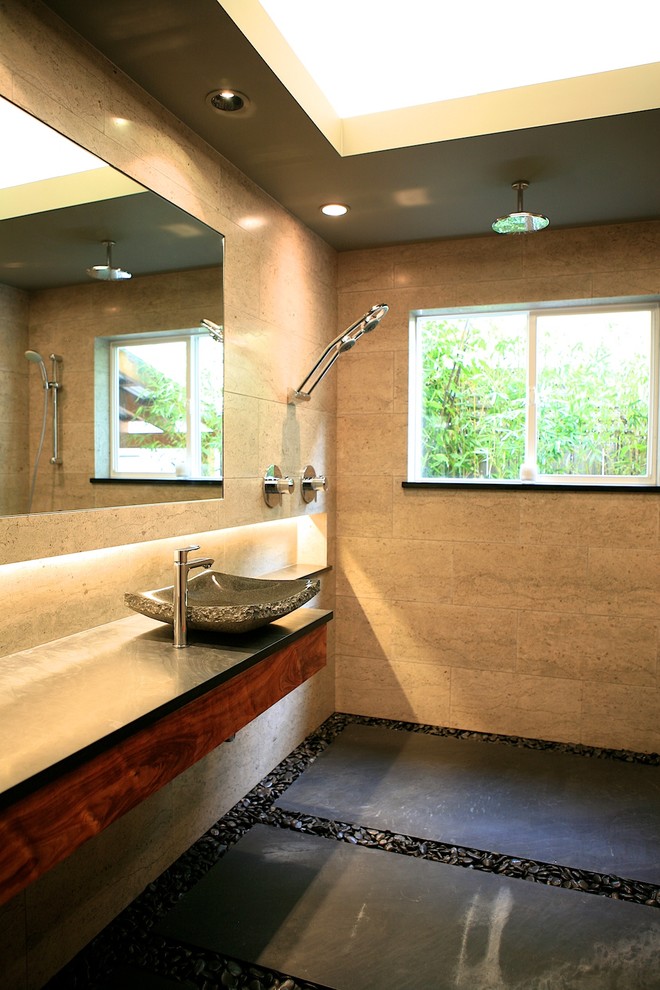 На фото: главная ванная комната среднего размера в восточном стиле с настольной раковиной, плоскими фасадами, темными деревянными фасадами, столешницей из талькохлорита, душем без бортиков, серой плиткой, каменной плиткой и серыми стенами