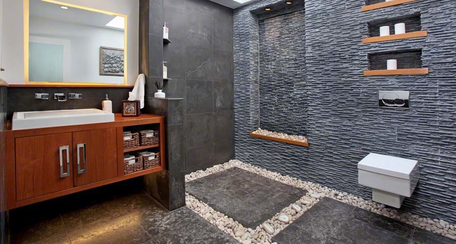 Inredning av ett modernt mellanstort en-suite badrum, med skåp i shakerstil, skåp i mellenmörkt trä, en kantlös dusch, en vägghängd toalettstol, svart kakel, stenkakel, klinkergolv i porslin, ett avlångt handfat, träbänkskiva och grått golv