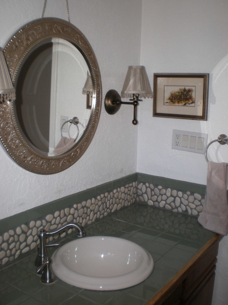 Kleines Stilmix Duschbad mit Einbauwaschbecken, flächenbündigen Schrankfronten, hellbraunen Holzschränken, gefliestem Waschtisch, grünen Fliesen, Steinfliesen und weißer Wandfarbe in Albuquerque