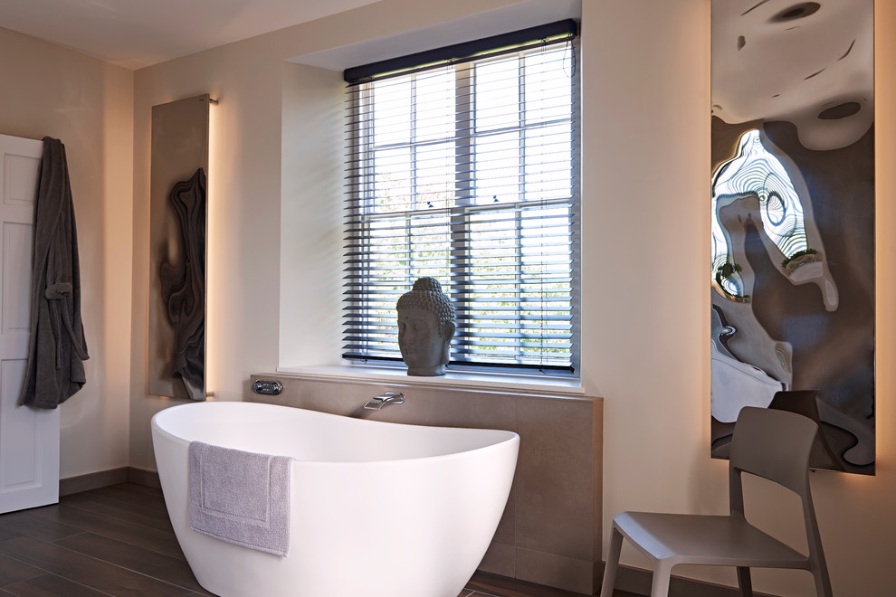 Immagine di una stanza da bagno padronale moderna di medie dimensioni con vasca freestanding, piastrelle beige, piastrelle di ciottoli, pareti beige e pavimento in gres porcellanato