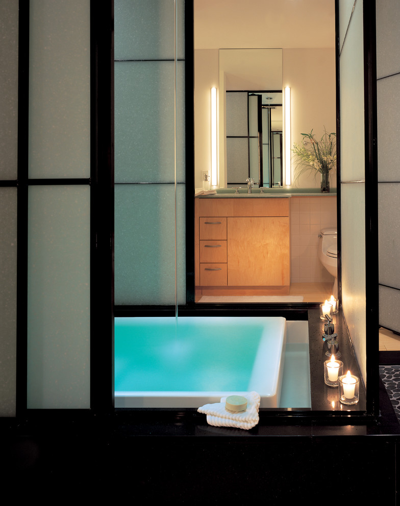На фото: главная ванная комната в стиле лофт с светлыми деревянными фасадами, бежевыми стенами, полом из керамической плитки, плоскими фасадами, японской ванной и бежевой плиткой с