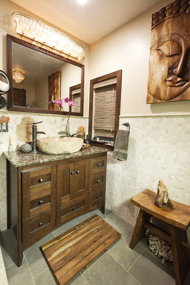 Diseño de cuarto de baño de estilo zen con lavabo sobreencimera, armarios estilo shaker, puertas de armario de madera oscura, encimera de granito, baldosas y/o azulejos beige, suelo de baldosas tipo guijarro y paredes beige