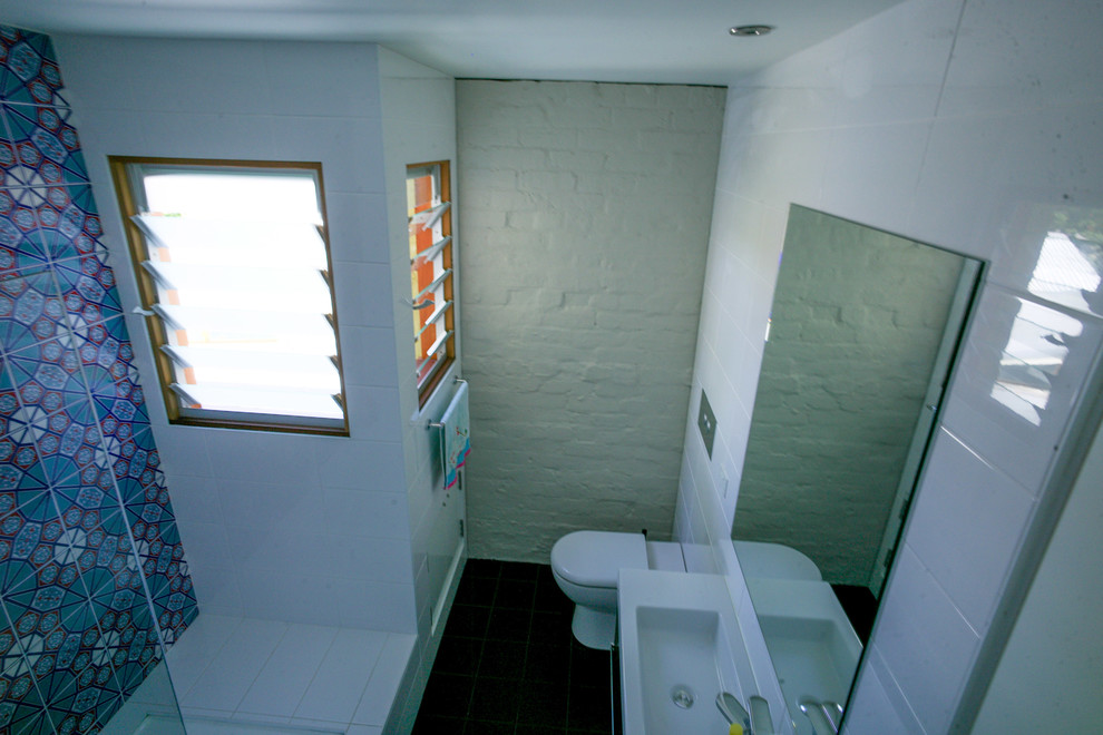 Aménagement d'une salle de bain contemporaine de taille moyenne avec un placard à porte plane, des portes de placard blanches, une baignoire posée, WC suspendus, un carrelage bleu, des carreaux de céramique, un mur blanc, un sol en carrelage de céramique et un lavabo intégré.