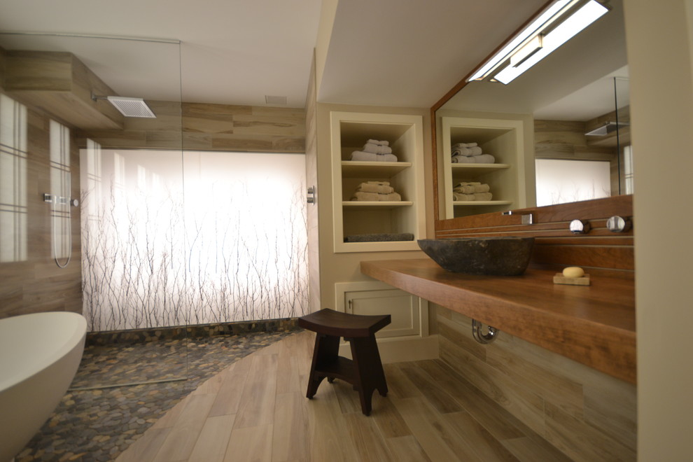 Стильный дизайн: большая главная ванная комната в восточном стиле с японской ванной, душем без бортиков, бежевой плиткой, галечной плиткой, бежевыми стенами, настольной раковиной и столешницей из дерева - последний тренд