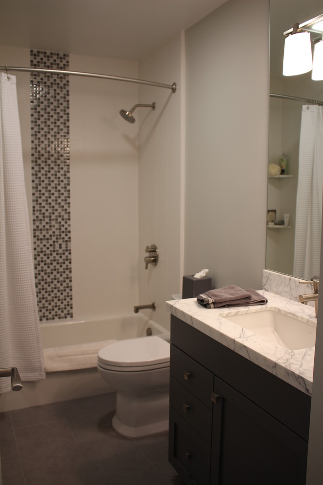 Cette photo montre une petite salle de bain tendance pour enfant avec un lavabo encastré, un placard à porte shaker, des portes de placard grises, un plan de toilette en marbre, une baignoire en alcôve, un combiné douche/baignoire, WC à poser, un carrelage blanc, des carreaux de porcelaine, un mur gris et un sol en carrelage de porcelaine.