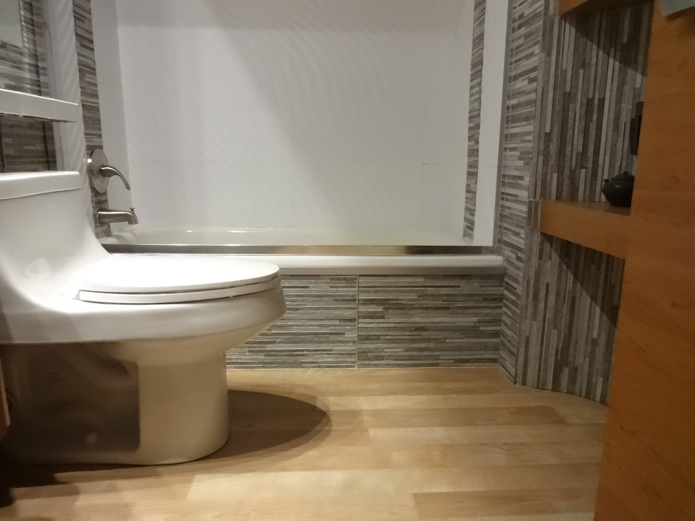 Immagine di una stanza da bagno con doccia etnica di medie dimensioni con WC monopezzo, pistrelle in bianco e nero, piastrelle in pietra, parquet chiaro, vasca ad alcova, vasca/doccia, pareti grigie, ante lisce, ante beige, lavabo integrato, top piastrellato, pavimento beige, porta doccia scorrevole, top bianco, nicchia, un lavabo e mobile bagno sospeso