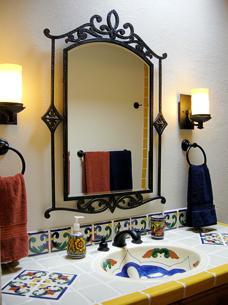 Klassisk inredning av ett mellanstort badrum med dusch, med luckor med upphöjd panel, skåp i ljust trä, en dusch i en alkov, en toalettstol med hel cisternkåpa, blå kakel, vit kakel, gul kakel, keramikplattor, vita väggar, tegelgolv, ett integrerad handfat, kaklad bänkskiva, rött golv och dusch med duschdraperi