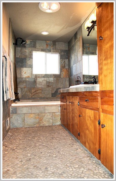 Inspiration for a mid-sized zen master pebble tile floor bathroom remodel in Portland with flat-panel cabinets, medium tone wood cabinets, beige walls and a drop-in sink