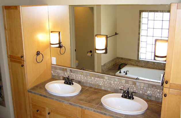 Immagine di una stanza da bagno padronale etnica di medie dimensioni con ante in stile shaker, ante in legno chiaro, vasca da incasso, WC monopezzo, piastrelle marroni, piastrelle grigie, piastrelle di ciottoli, pareti beige e lavabo da incasso