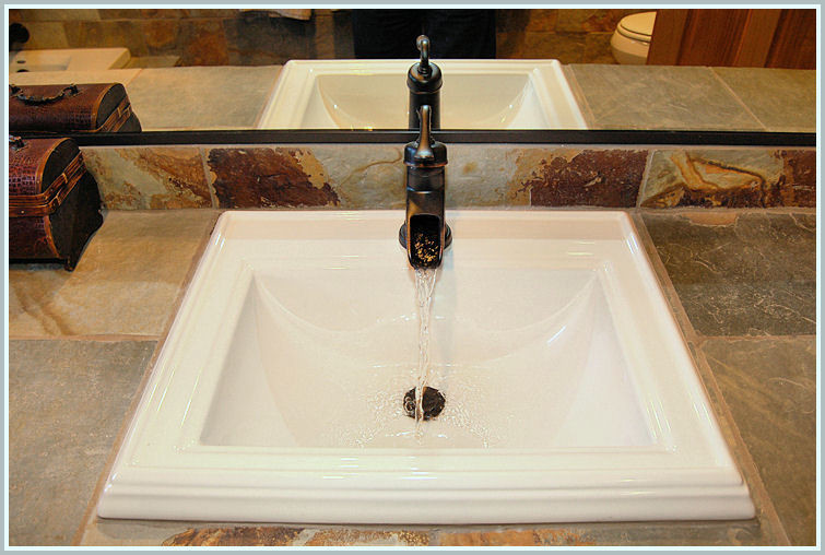 Cette photo montre une salle de bain principale sud-ouest américain en bois brun de taille moyenne avec WC à poser, un lavabo posé et un placard avec porte à panneau surélevé.