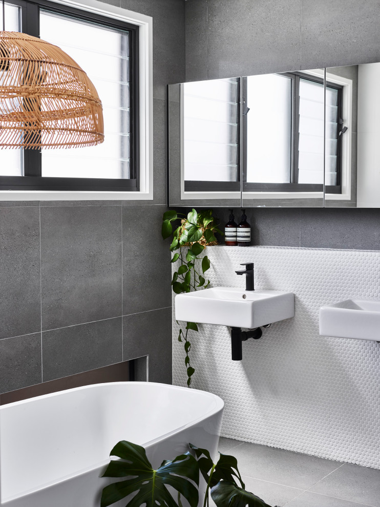 Modern inredning av ett litet en-suite badrum, med ett fristående badkar, vit kakel, mosaik, klinkergolv i keramik och grått golv