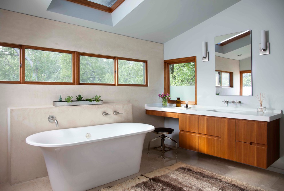 Modelo de cuarto de baño principal contemporáneo con lavabo bajoencimera, armarios con paneles lisos, puertas de armario de madera oscura y bañera exenta