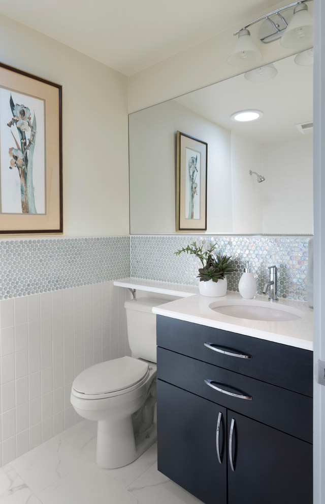 На фото: ванная комната в современном стиле с врезной раковиной, плоскими фасадами, черными фасадами, раздельным унитазом и белой плиткой с