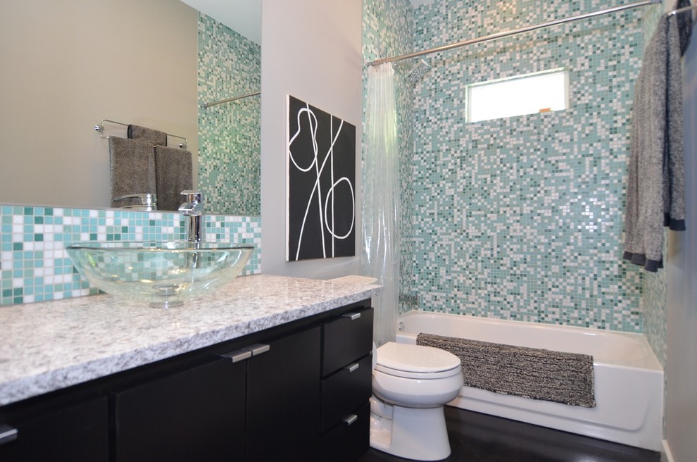 Esempio di una stanza da bagno per bambini design di medie dimensioni con lavabo a bacinella, ante nere, vasca/doccia, WC sospeso, piastrelle blu, piastrelle di vetro e pareti multicolore