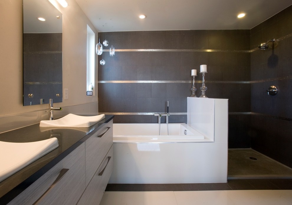 Medium sized modern ensuite bathroom in New York with grey cabinets, black tiles, glass tiles and black walls.