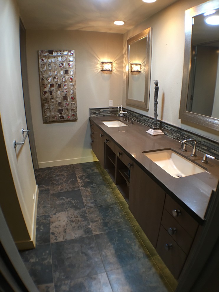 Example of a mid-sized eclectic 3/4 black tile and stone slab slate floor bathroom design in Portland with flat-panel cabinets, medium tone wood cabinets, a drop-in sink, beige walls and solid surface countertops