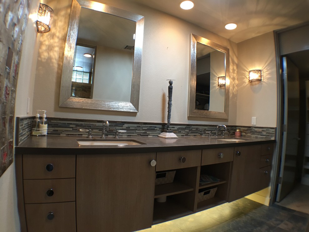 Foto di una stanza da bagno con doccia boho chic di medie dimensioni con ante lisce, ante in legno scuro, piastrelle nere, lastra di pietra, lavabo da incasso, pareti beige e top in superficie solida