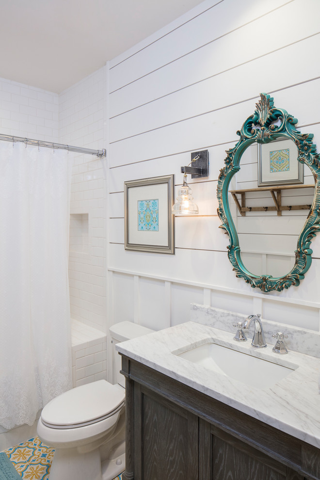 Inredning av ett lantligt mellanstort badrum, med skåp i mörkt trä, en dusch/badkar-kombination, vit kakel, tunnelbanekakel, vita väggar, ett undermonterad handfat, dusch med duschdraperi och luckor med infälld panel