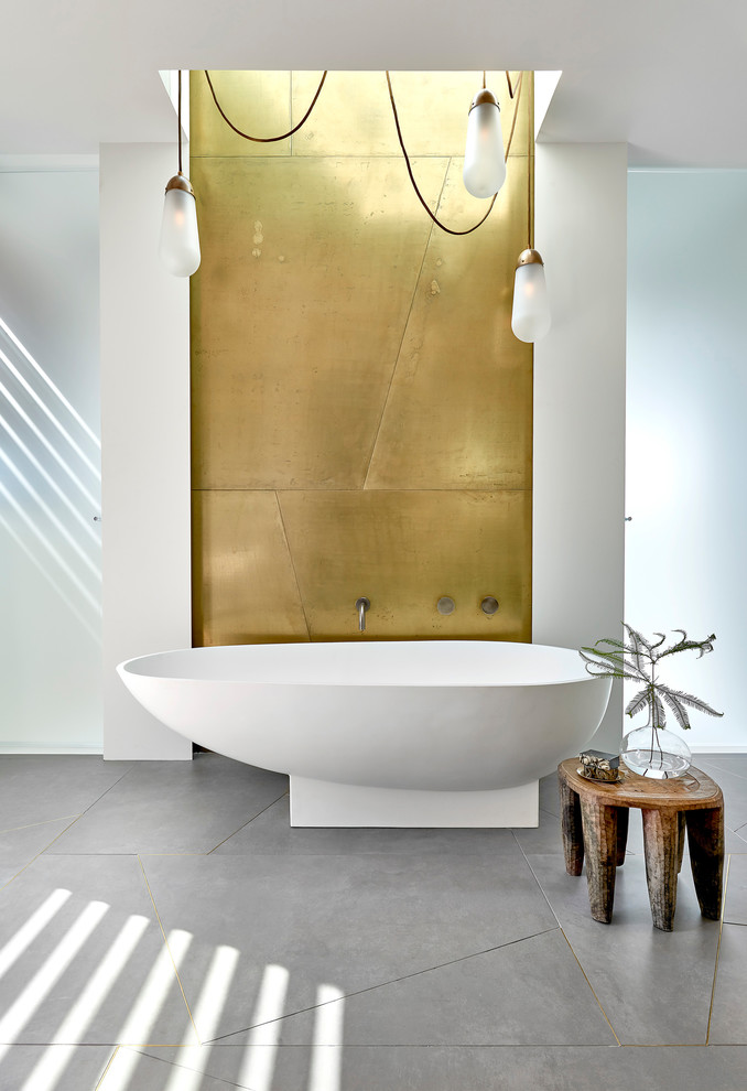 Ispirazione per una stanza da bagno design con vasca freestanding, pavimento in cemento, top bianco, pareti bianche e pavimento grigio