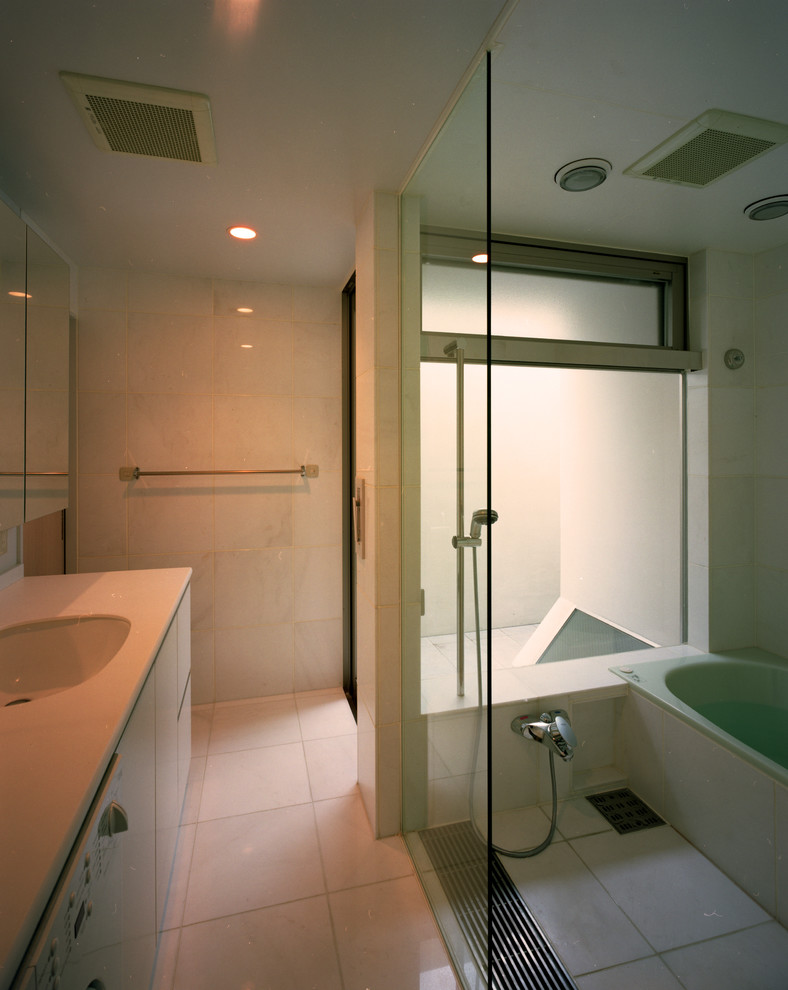 На фото: главная ванная комната среднего размера в стиле модернизм с фасадами с декоративным кантом, белыми фасадами, накладной ванной, душем над ванной, унитазом-моноблоком, белой плиткой, мраморной плиткой, белыми стенами, мраморным полом, врезной раковиной, столешницей из искусственного камня, белым полом, душем с распашными дверями и белой столешницей