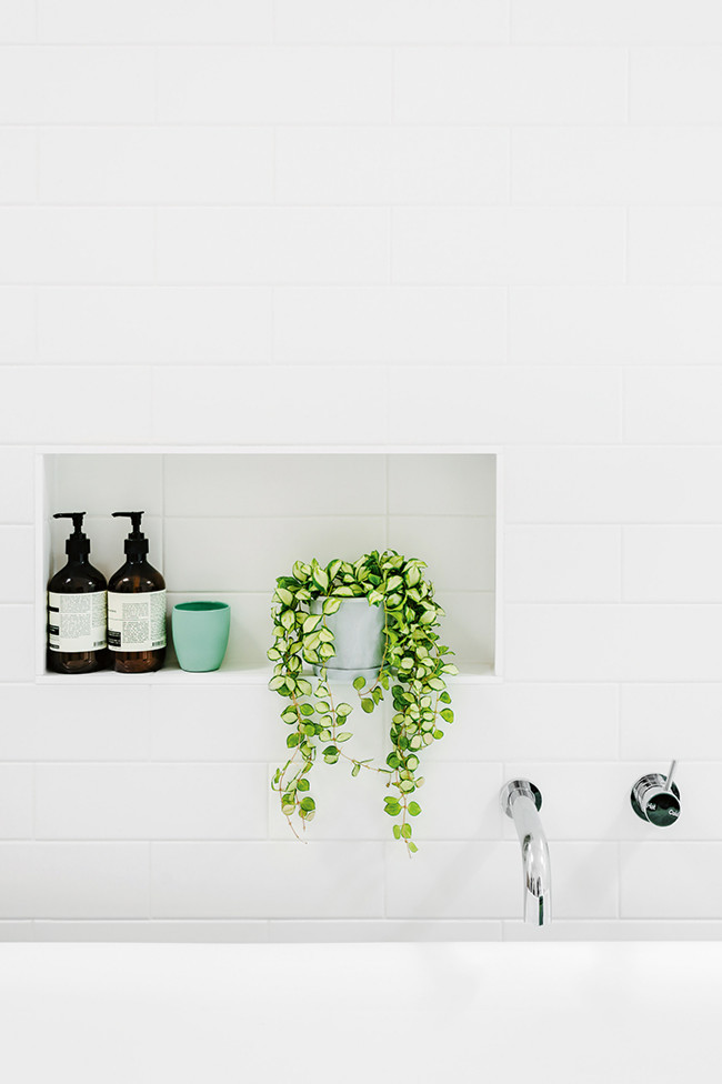 Imagen de cuarto de baño principal nórdico de tamaño medio con lavabo bajoencimera, bañera exenta, ducha a ras de suelo, baldosas y/o azulejos blancos y paredes blancas